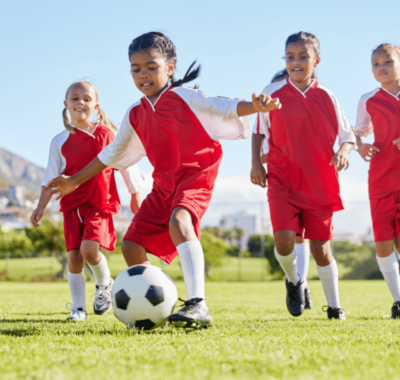Young girls playing soccer showing how we practice