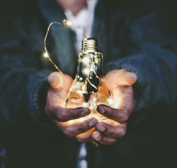 Man holding light globe in hands as emergent value. Photo credit: Riccardo Annandale